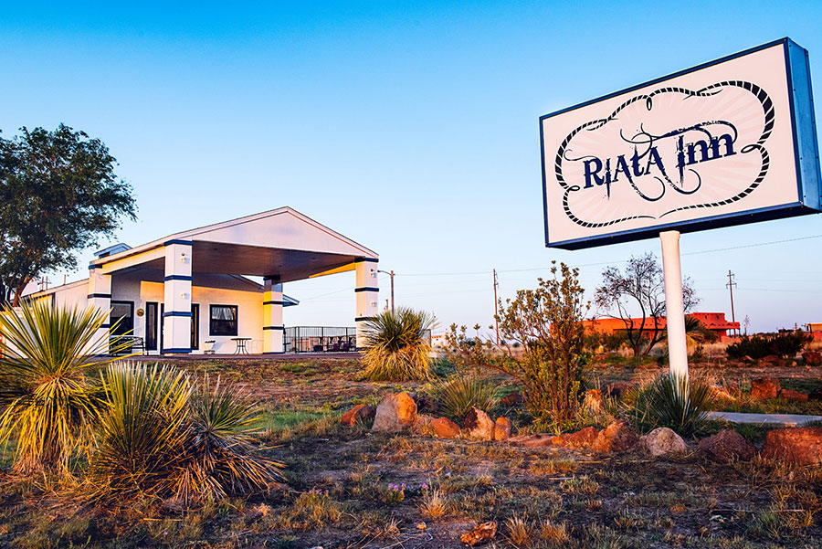 exterior building and road sign of Riata Inn Marfa